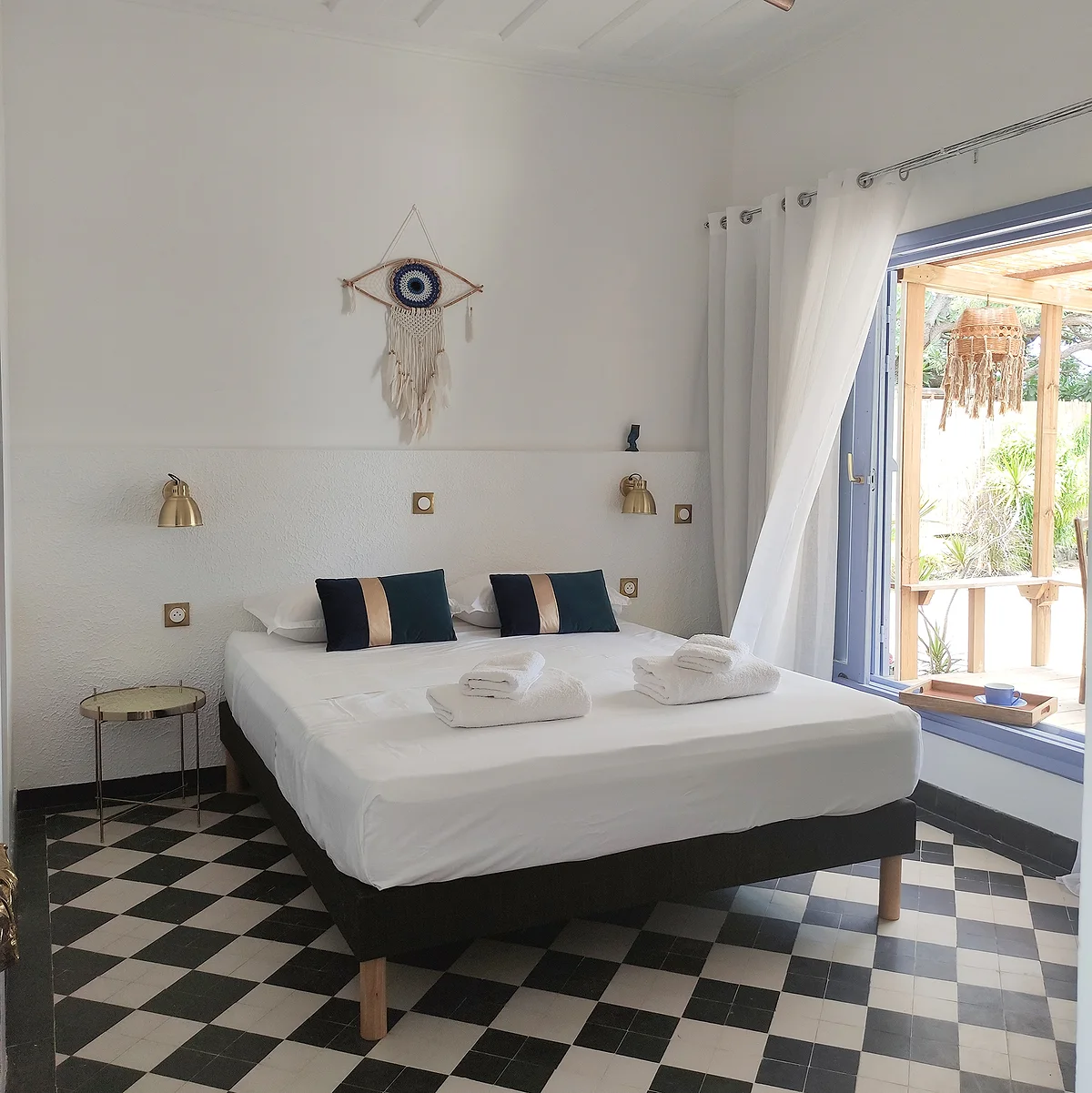 La chambre Athéna, son sol en damier noir et blanc et son lit aux coussins verts