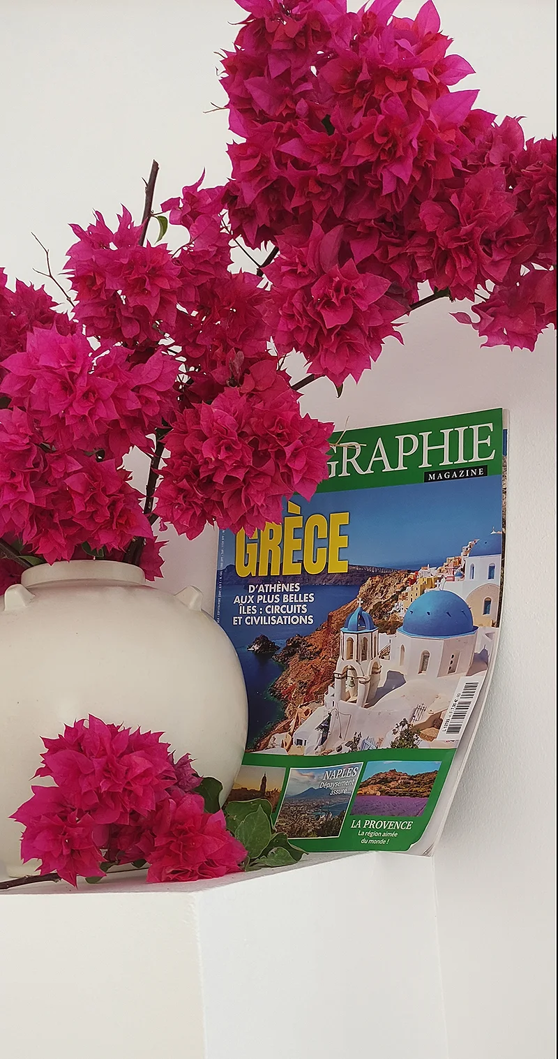 Un bouquet de bougainvillier et un magazine sur la Grèce dans le patio