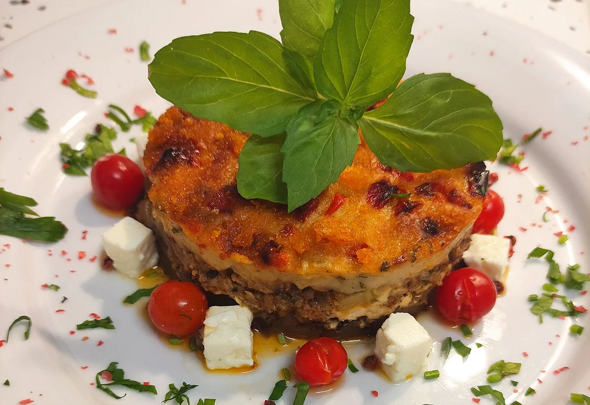 La moussaka du chef Thanos, garnie de tomates, de feta et de basilic