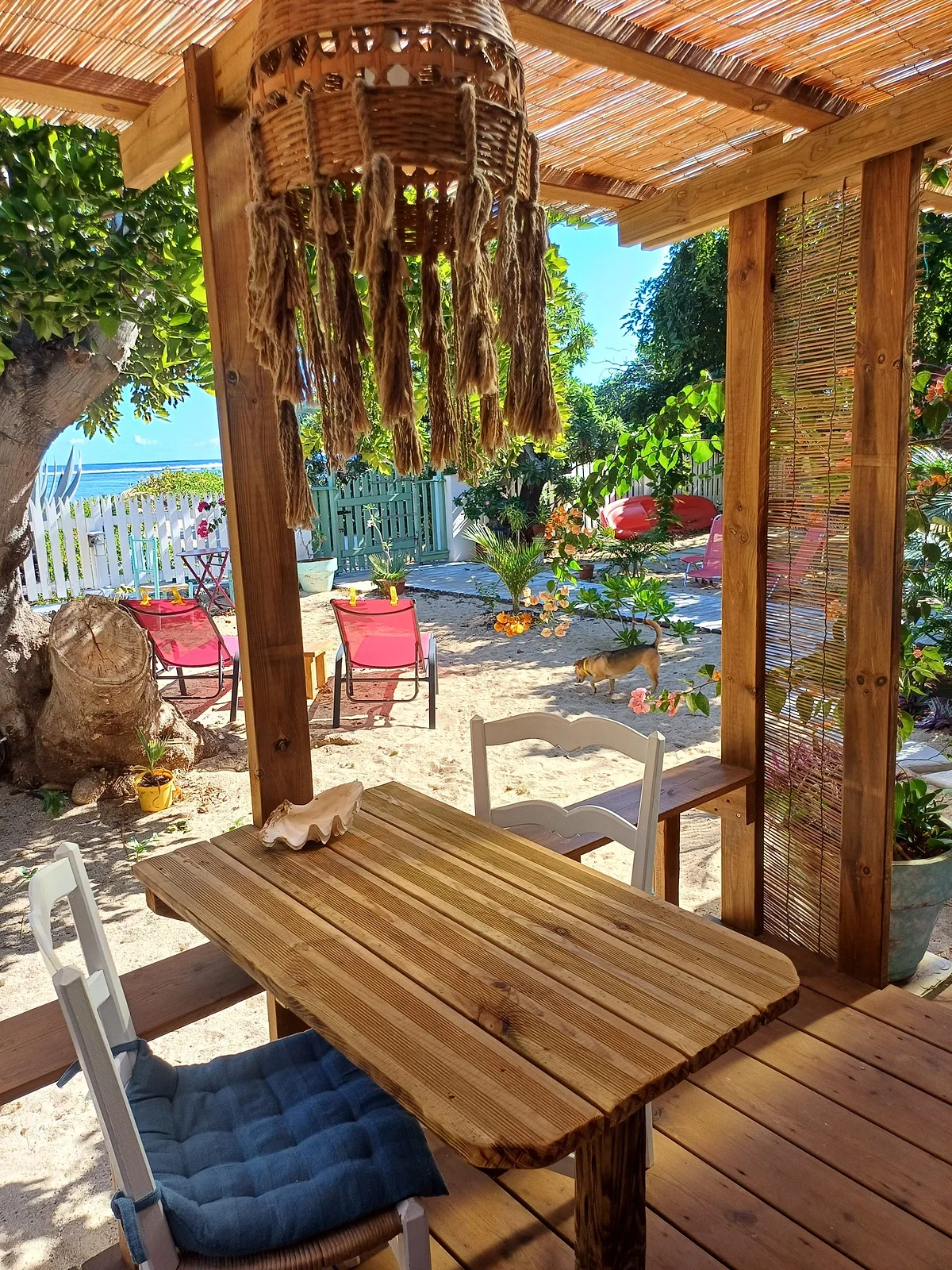 La terrasse sous la pergola, ouverte sur la plage